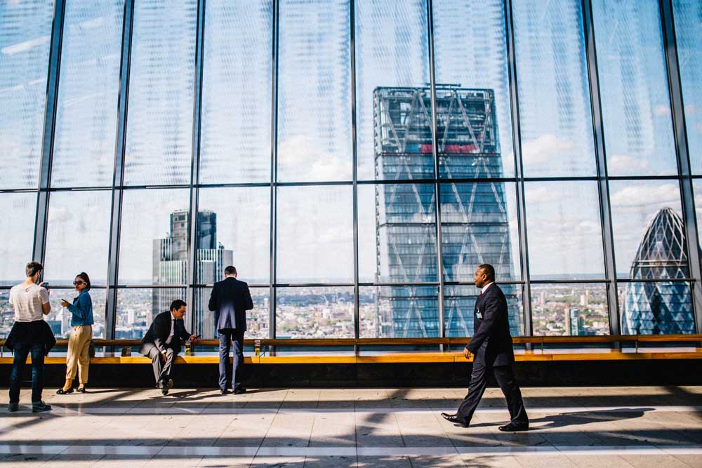 man walking through high rise city view
