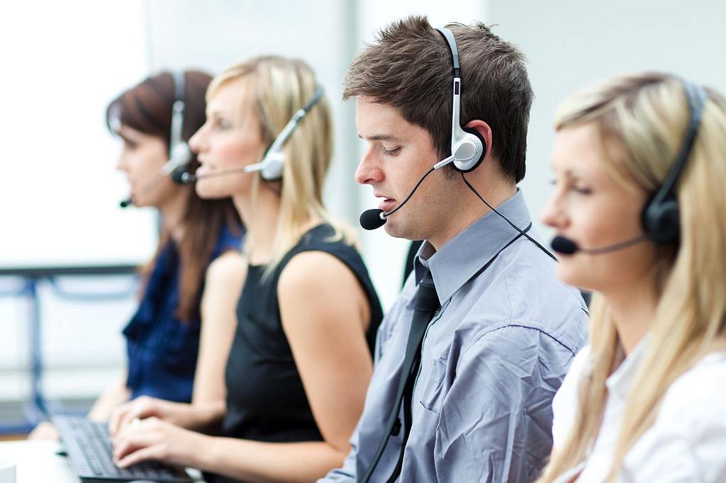 row of call center agents talking into headsets