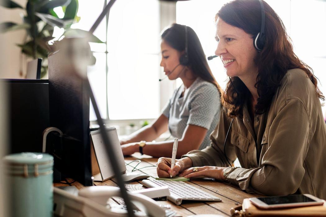 customer support team taking notes and talking on the phone