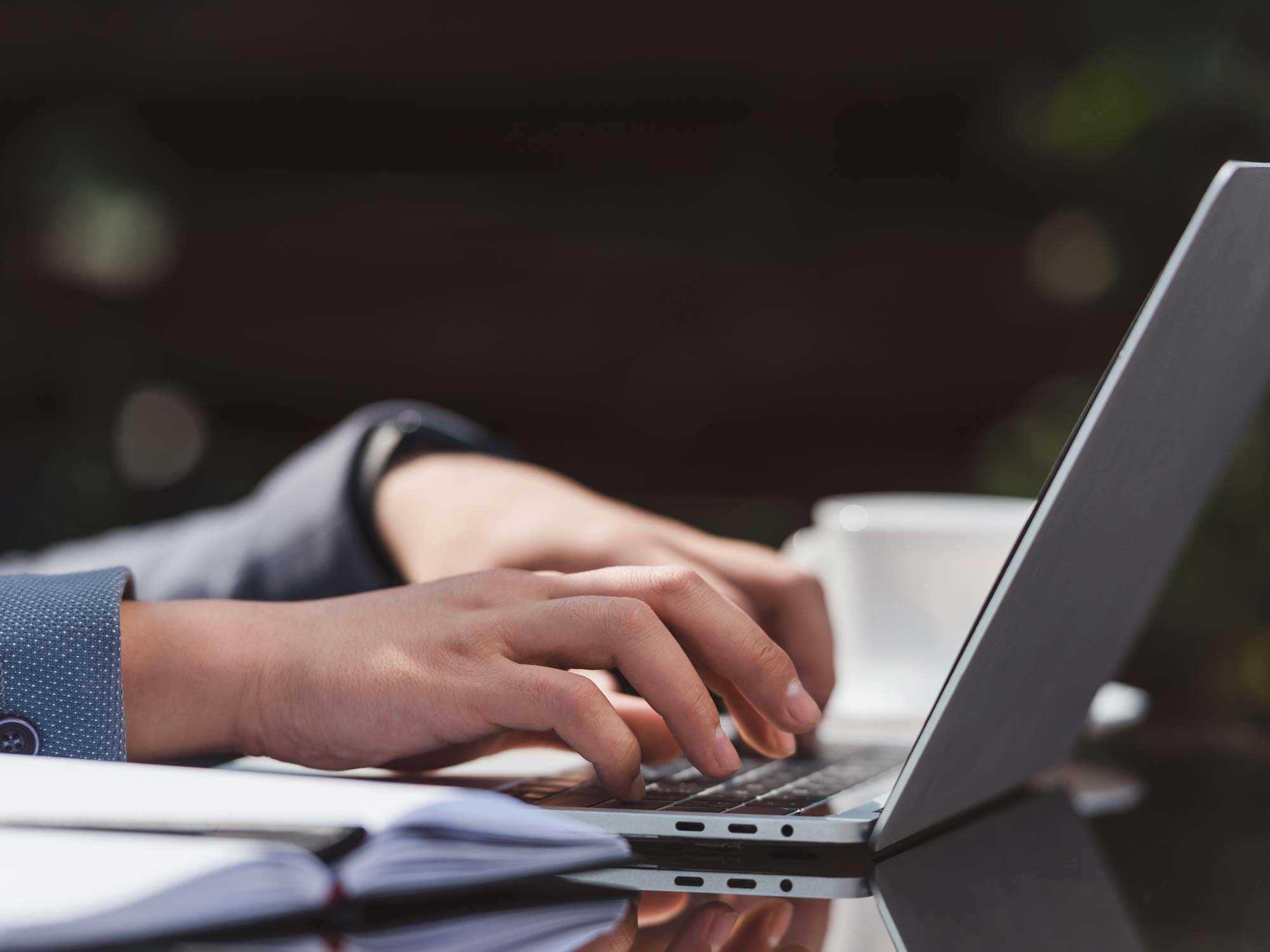 close up of man typing on laptop