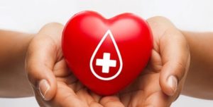 hand holding heart with american red cross symbol