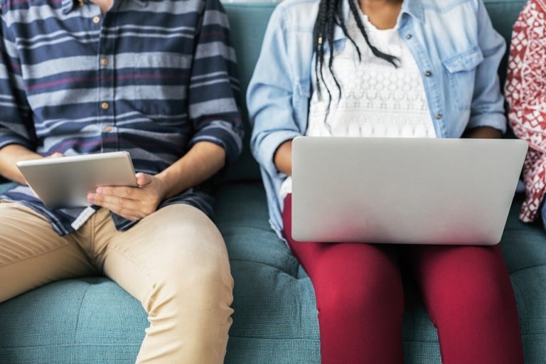 people using devices on couch