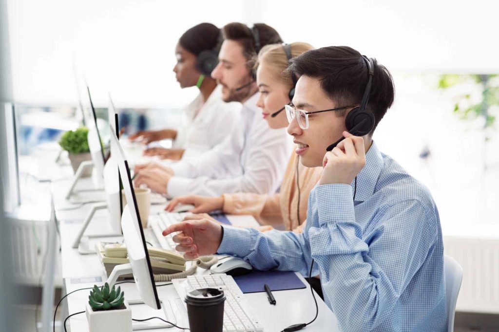 call center agents with headsets sitting at computers