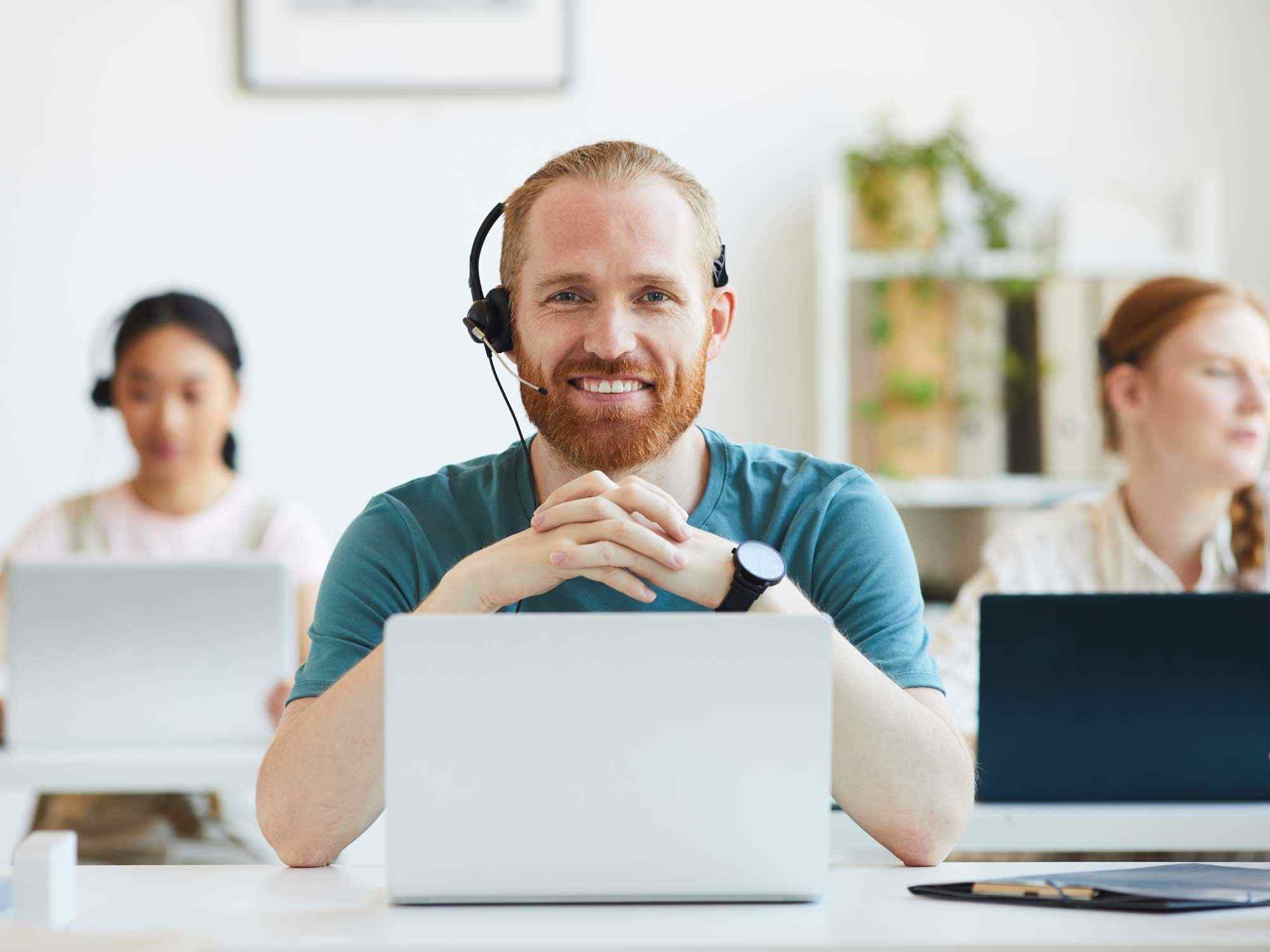 smiling contact center agents with laptops