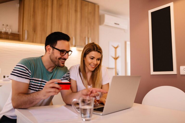 happy young couple paying utility bill online