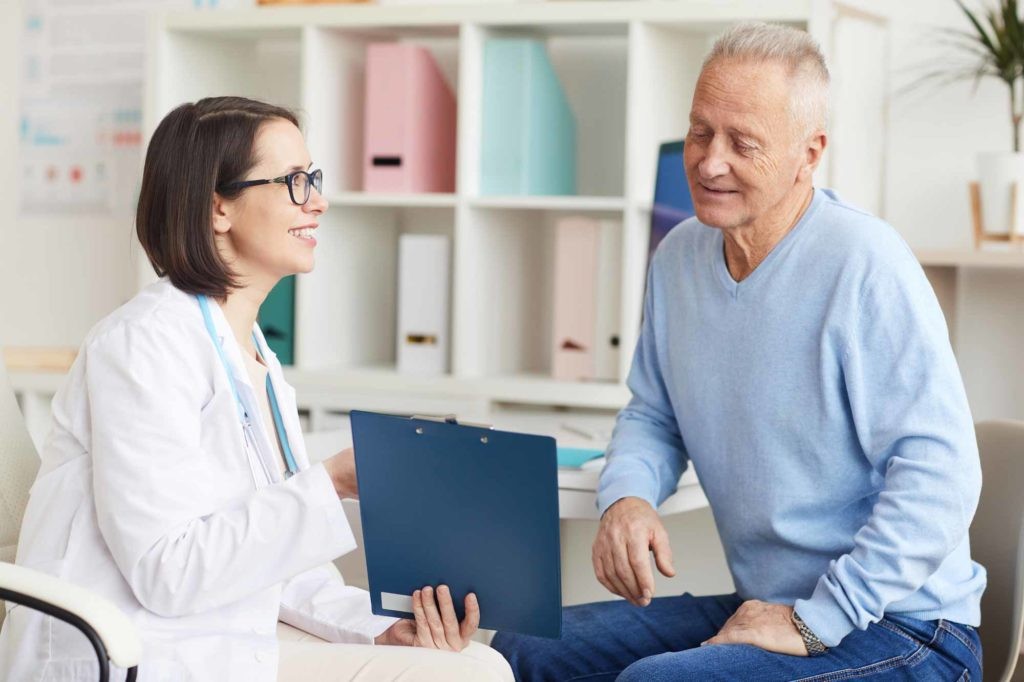 elderly patient and doctor reviewing results on clipboard