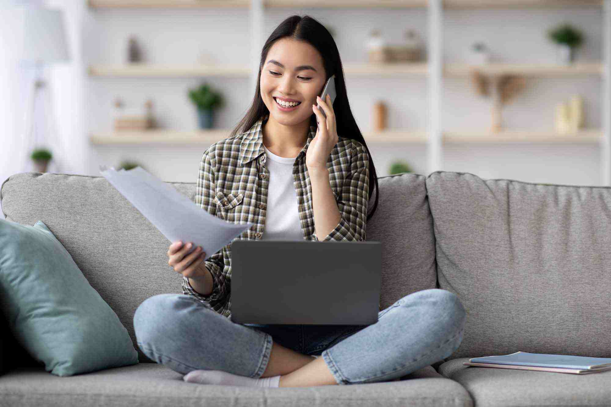 smiling woman on a couch talking on the phone