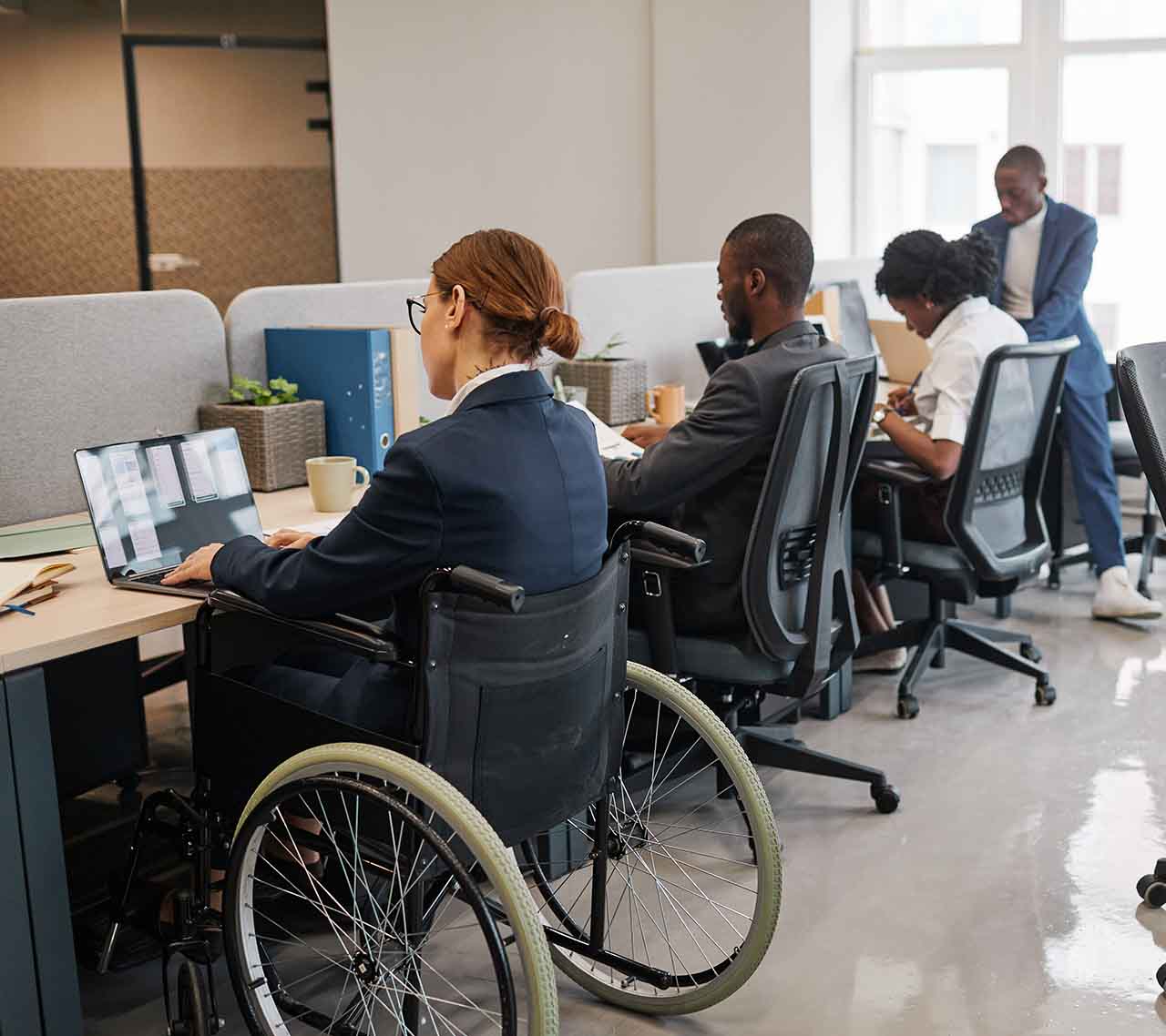 businesswoman in wheelchair working with diverse colleagues