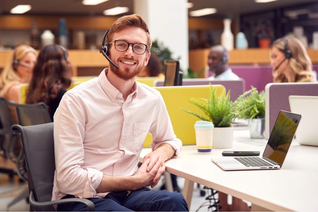 smiling call center agent working in outsourcing office