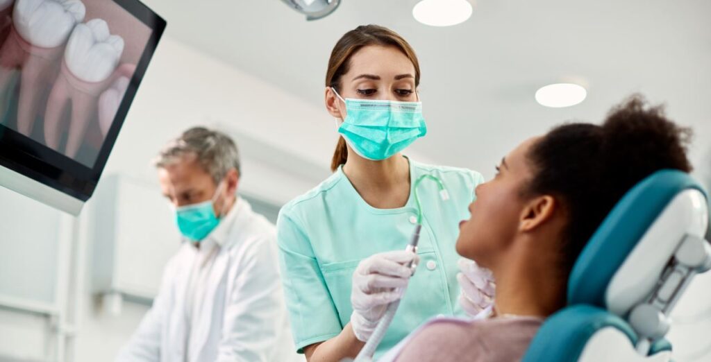 dentist and dental assistant in masks with a patient during an appointment
