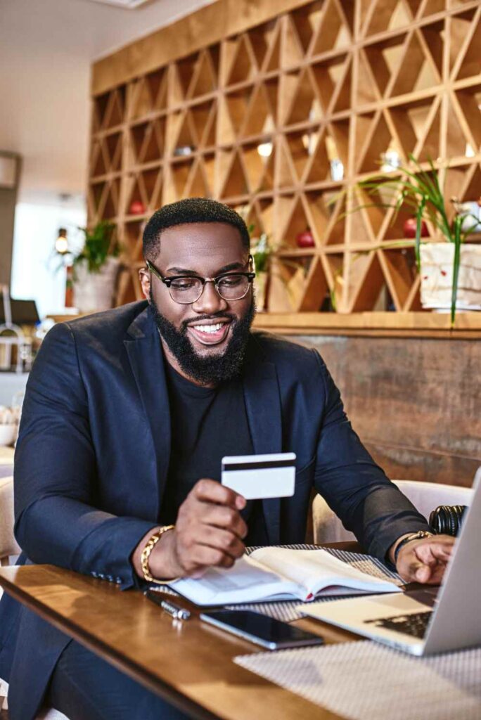 smiling customer on a laptop making a payment with a credit card